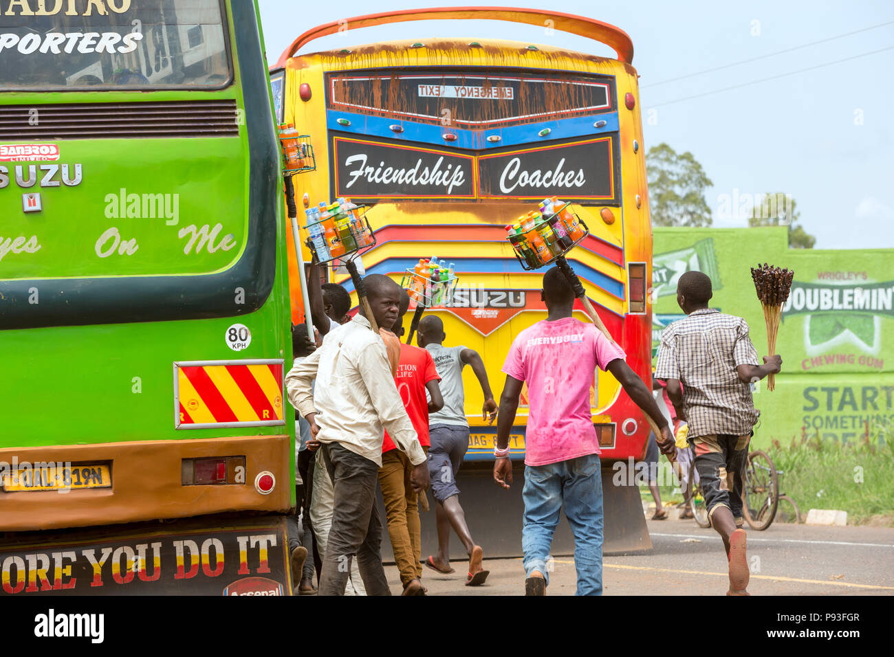 Kamdini, Ouganda - Flying courtiers à un arrêt de bus. Les habitants suivent un bus de banlieue avec des marchandises. Banque D'Images