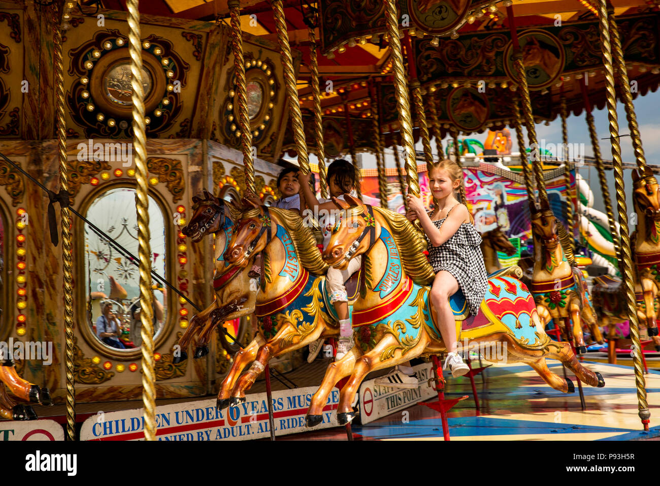 Royaume-uni, Angleterre, dans le Lancashire, Blackpool, pilier sud, les enfants équitation sur des chevaux du carrousel de foire Banque D'Images