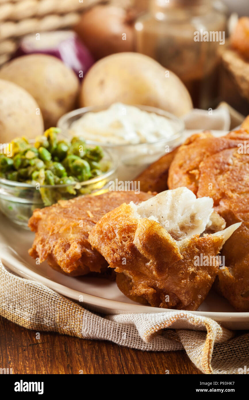Le poisson dans la pâte traditionnelle de la bière et des frites avec de petits pois et sauce tartare Banque D'Images