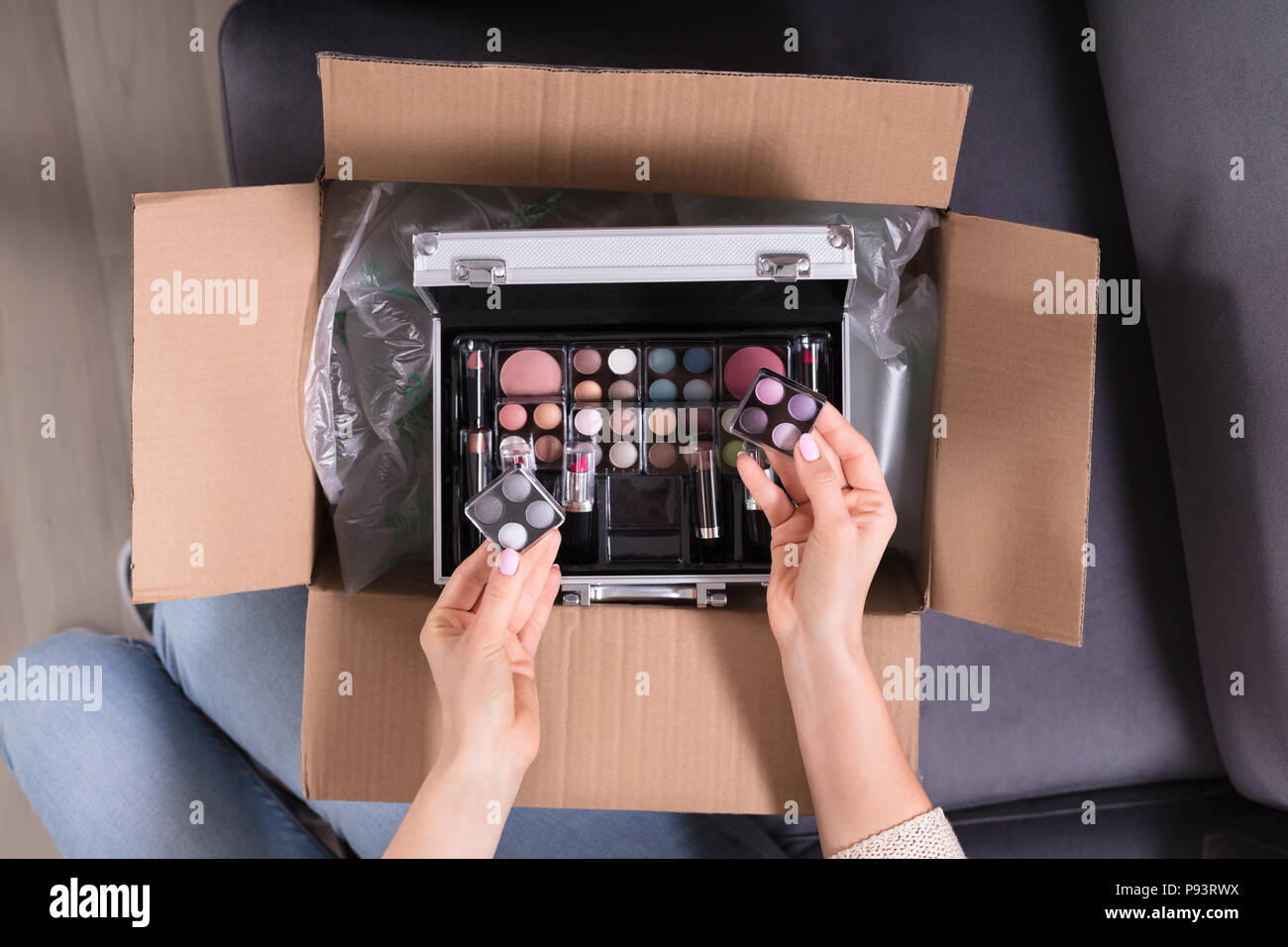 High Angle View Of A Woman's Hand Holding Produits cosmétiques de boîte en carton Banque D'Images