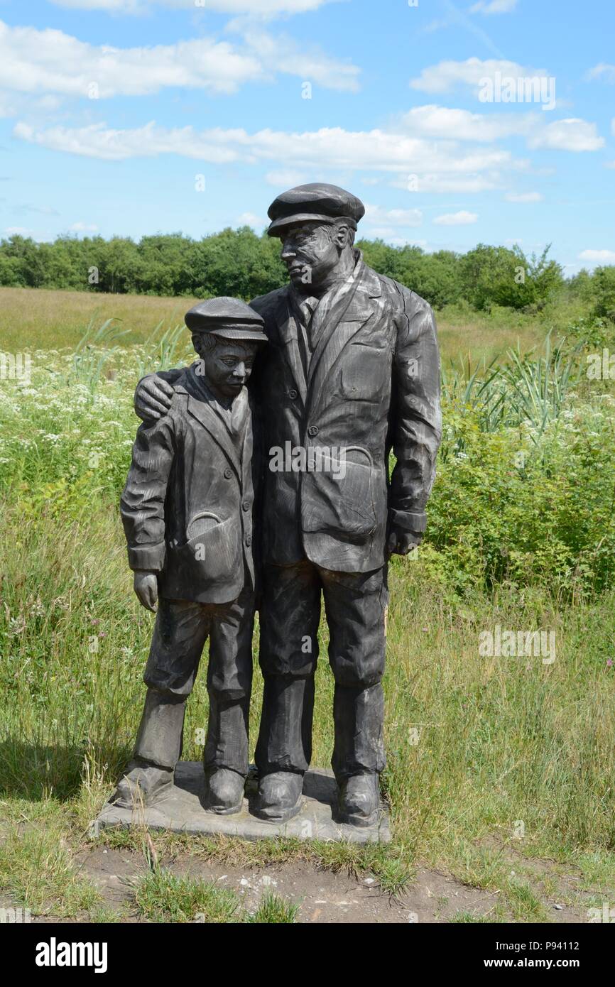 Sculpture en bois d'un mineur de charbon père et fils au parc La réserve naturelle de la mine de récupération 112 hommes et garçons ont perdu la vie Aberkenfig au Pays de Galles Banque D'Images
