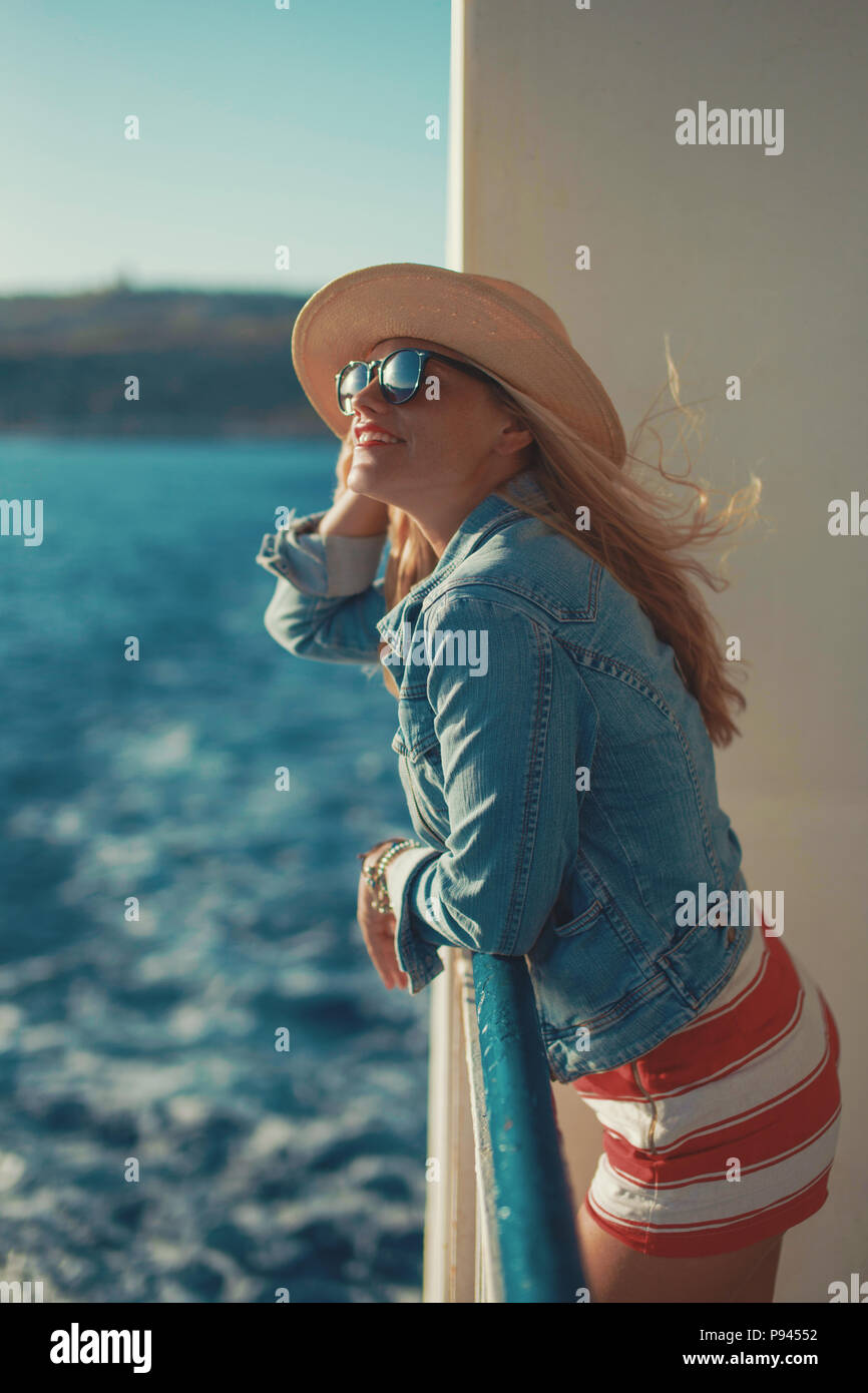 Voyageur blonde woman in hat on cruise ship looking away Banque D'Images