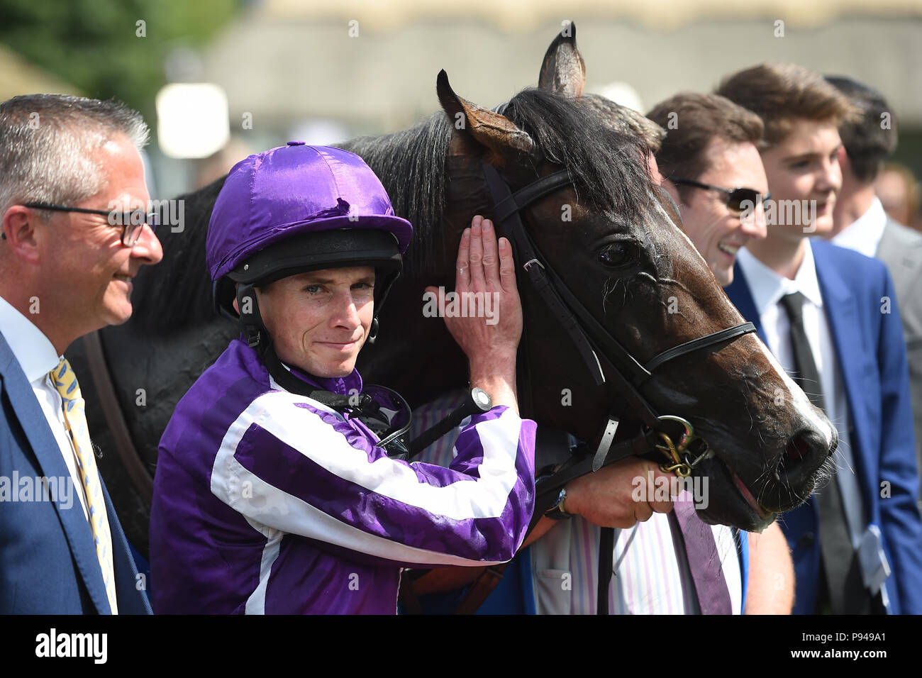 Ryan Moore avec drapeau de la Marine américaine après avoir remporté la Coupe Darley Juillet enjeux au cours de la troisième journée du Festival Juillet Moet & Chandon à Newmarket Racecourse. Banque D'Images