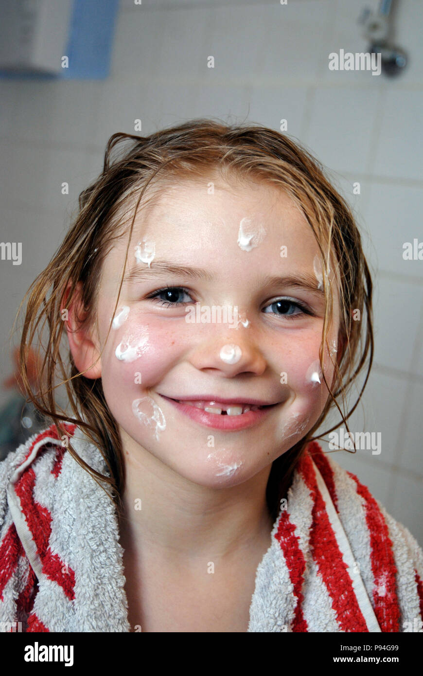 Emma mit Hautcreme-Tupfern im Gesicht Banque D'Images