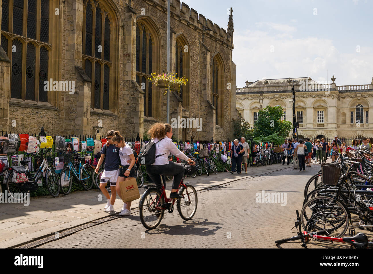 Un cycliste rides passé Grand St Marys church avec en arrière-plan du Kings College, Cambridge, UK Banque D'Images