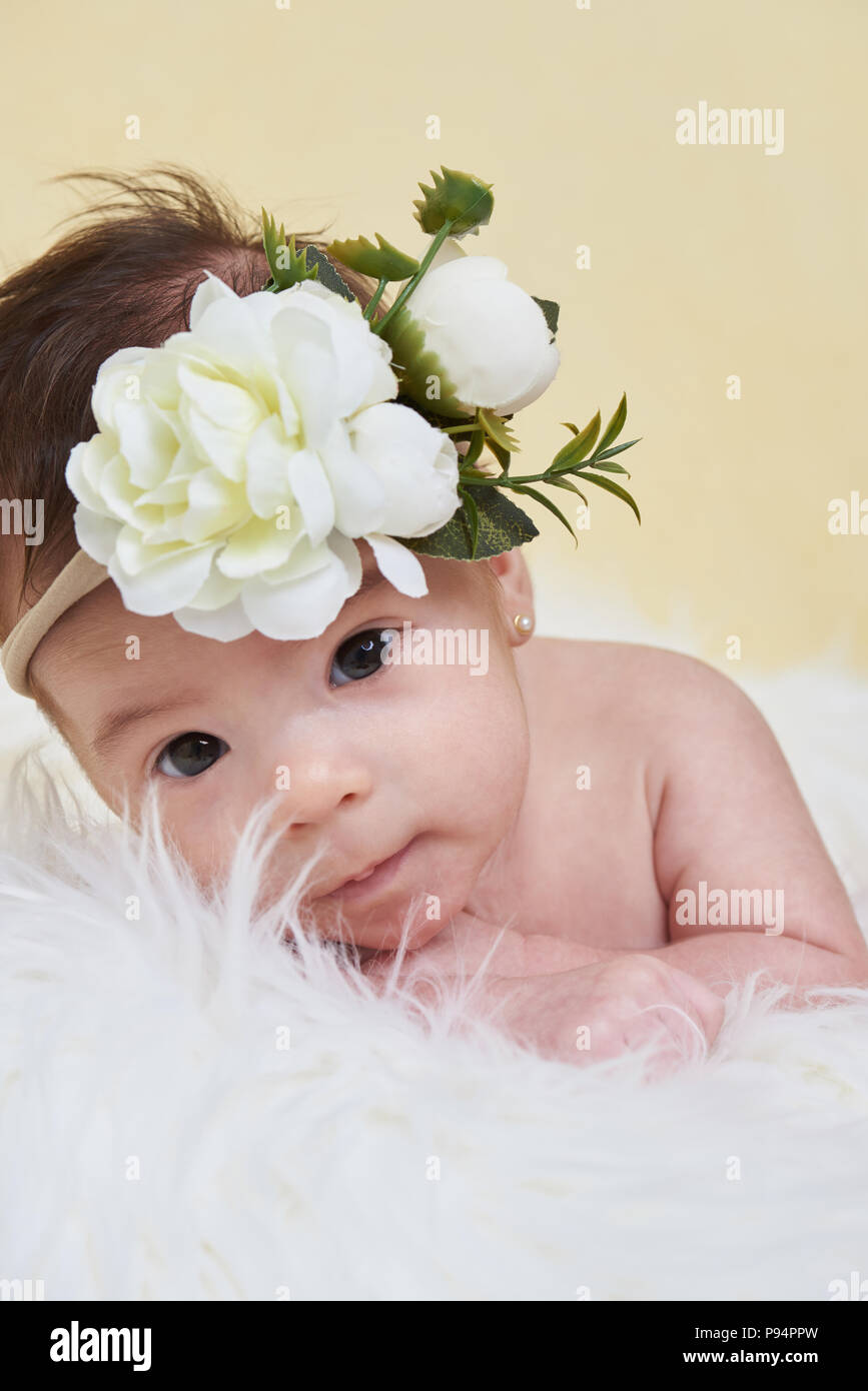 Newborm avec bébé fleur sur tête portrait sur un fond jaune Banque D'Images