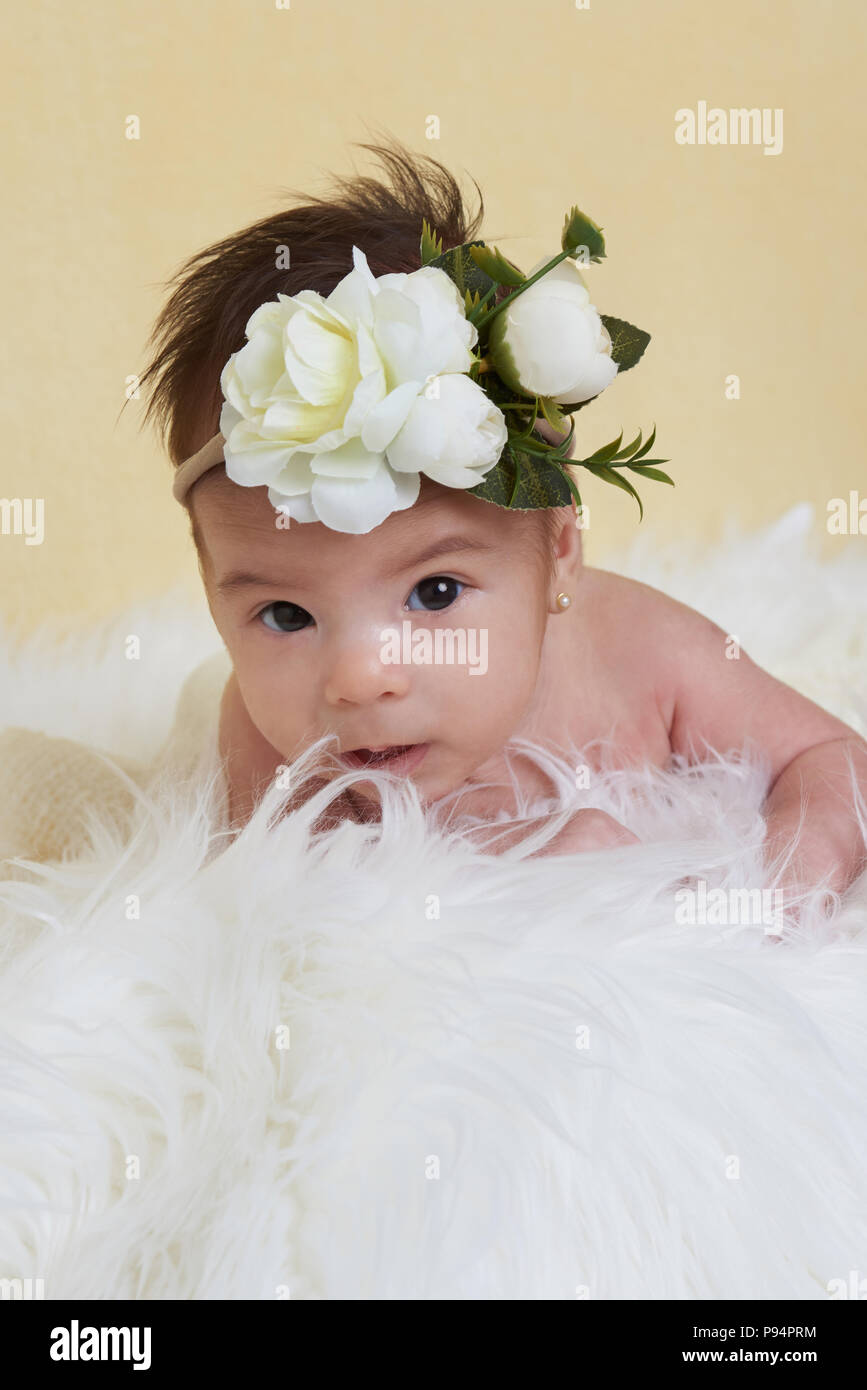 Baby Girl avec bow fleur jaune sur fond flou Banque D'Images