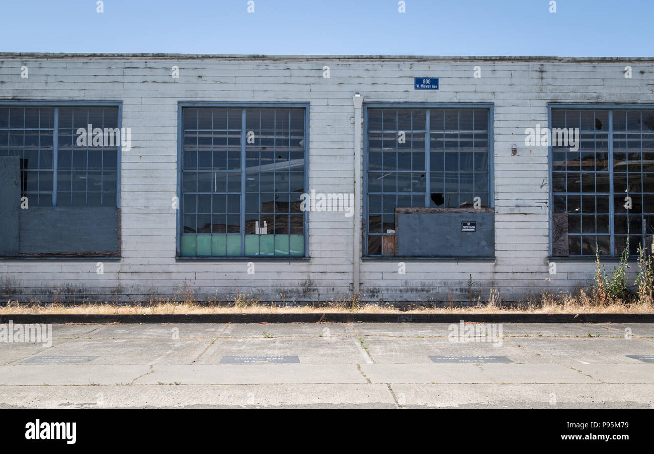 Un bâtiment abandonné à l'old Naval Air Station à Alameda, avec des fenêtres cassées et des murs en décomposition. Banque D'Images