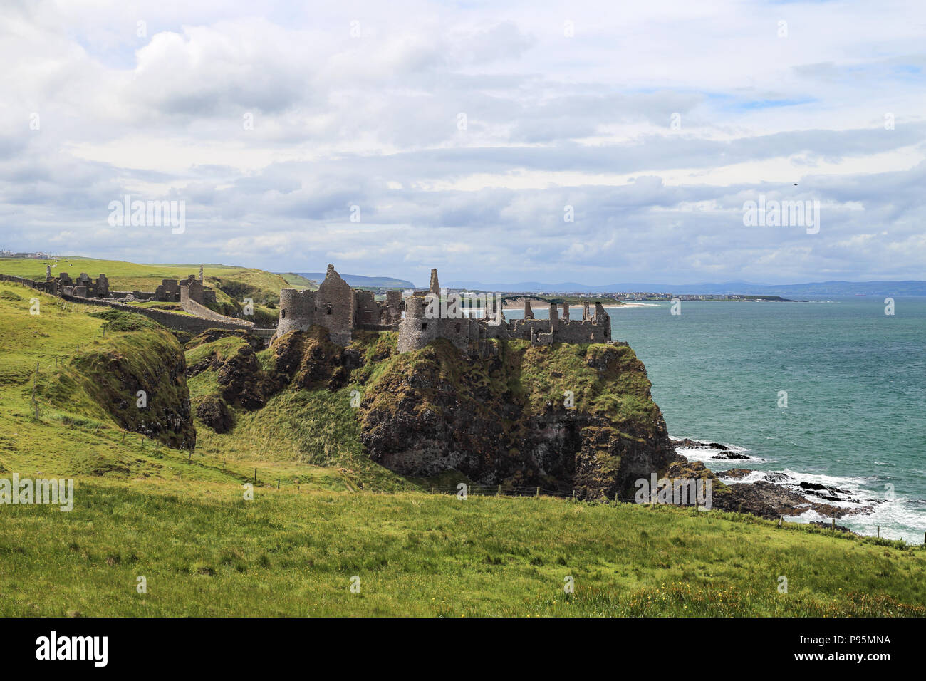 Le Château de Dunluce est un château médiéval en ruine maintenant en Irlande du Nord. Il est situé sur le bord d'un affleurement de basalte dans le comté d'Antrim. Banque D'Images