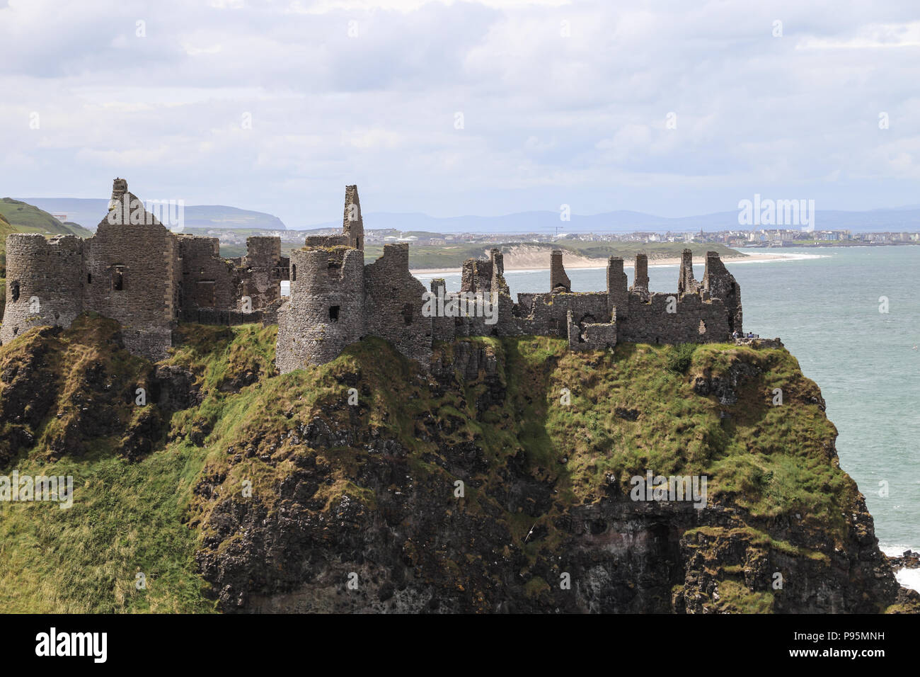 Le Château de Dunluce est un château médiéval en ruine maintenant en Irlande du Nord. Il est situé sur le bord d'un affleurement de basalte dans le comté d'Antrim. Banque D'Images