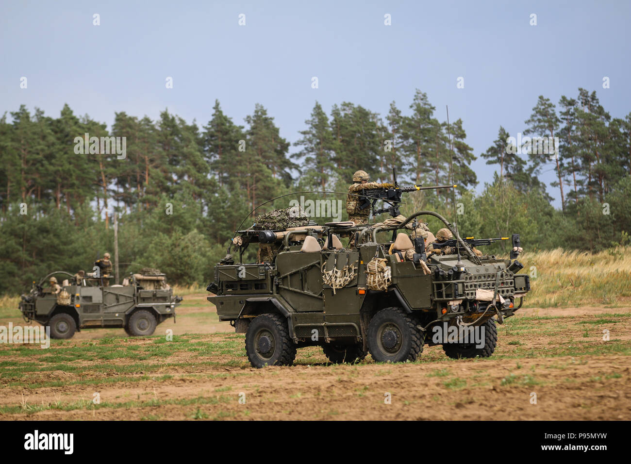 La mobilité de l'armée britannique Weapon-Mounted Kit d'installation "chacals" avec le 1er le Queen's Dragoon Guards fire sur ses ennemis au cours de la 15e Brigade mécanisée du réservoir d'une célébration de la Bataille de Pologne Groupe Orzysz, Pologne le 14 juillet 2018. La Pologne est un groupe de combat, unique coalition multinationale d'États-Unis, Royaume-Uni, croate et soldats roumains qui servent avec la 15e Brigade mécanisée polonaise comme une force de dissuasion de l'OTAN à l'appui de l'amélioration de l'avant la Présence. (U.S. Photo de l'armée par la CPS. Hubert D. Delany III /22e Détachement des affaires publiques mobiles) Banque D'Images