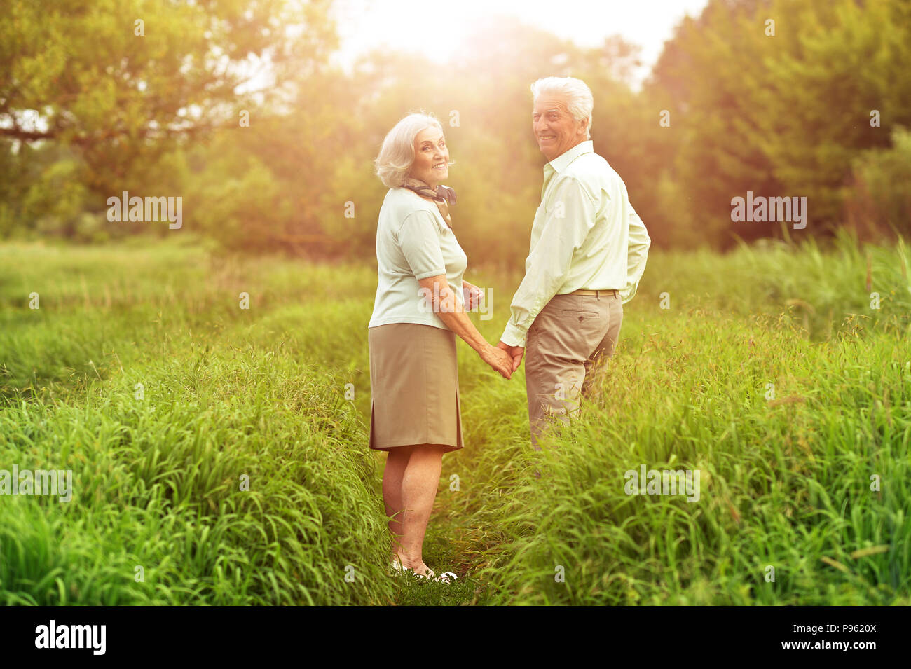 Senior couple walking on pré vert en été Banque D'Images
