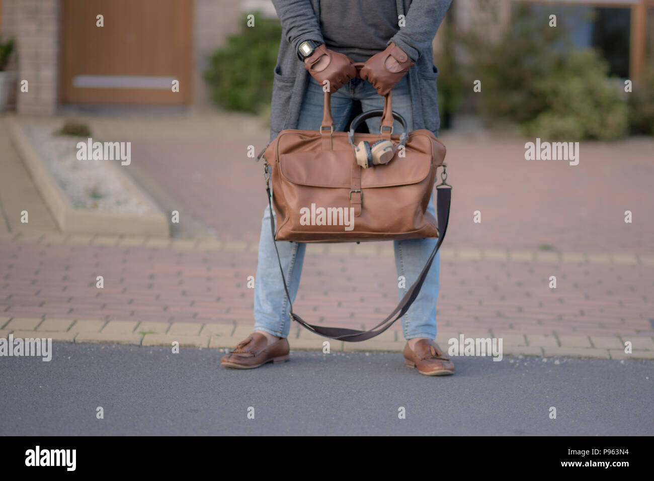 Homme avec des chaussures en cuir, sac en cuir, gants de cuir Banque D'Images