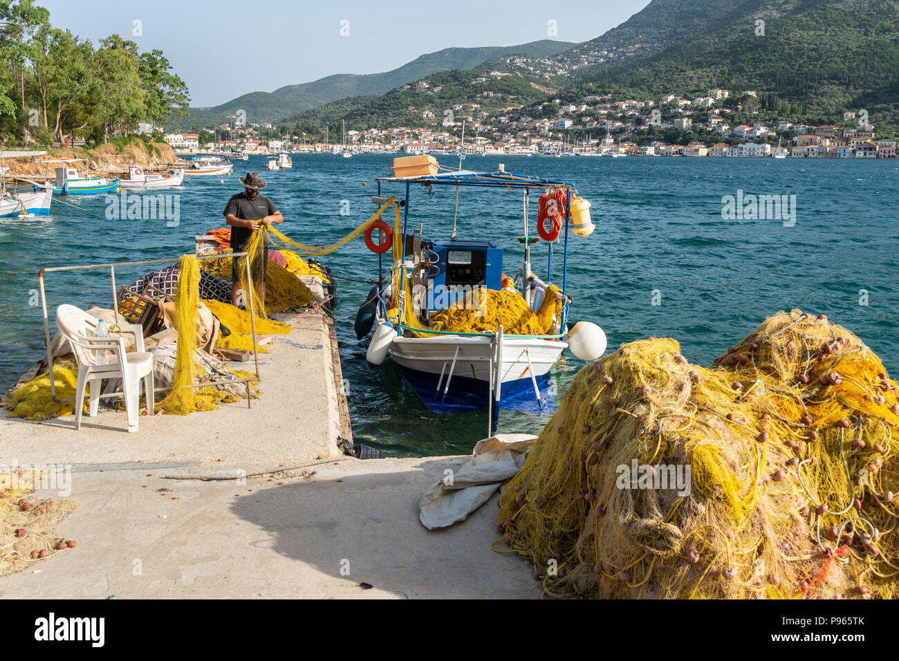Les pêcheurs et les filets de pêche sur le port du nord au quai du port de Vathy avec la ville de Vathy en arrière-plan. Sur l'île d'Ithaque, Mer Ionienne, G Banque D'Images