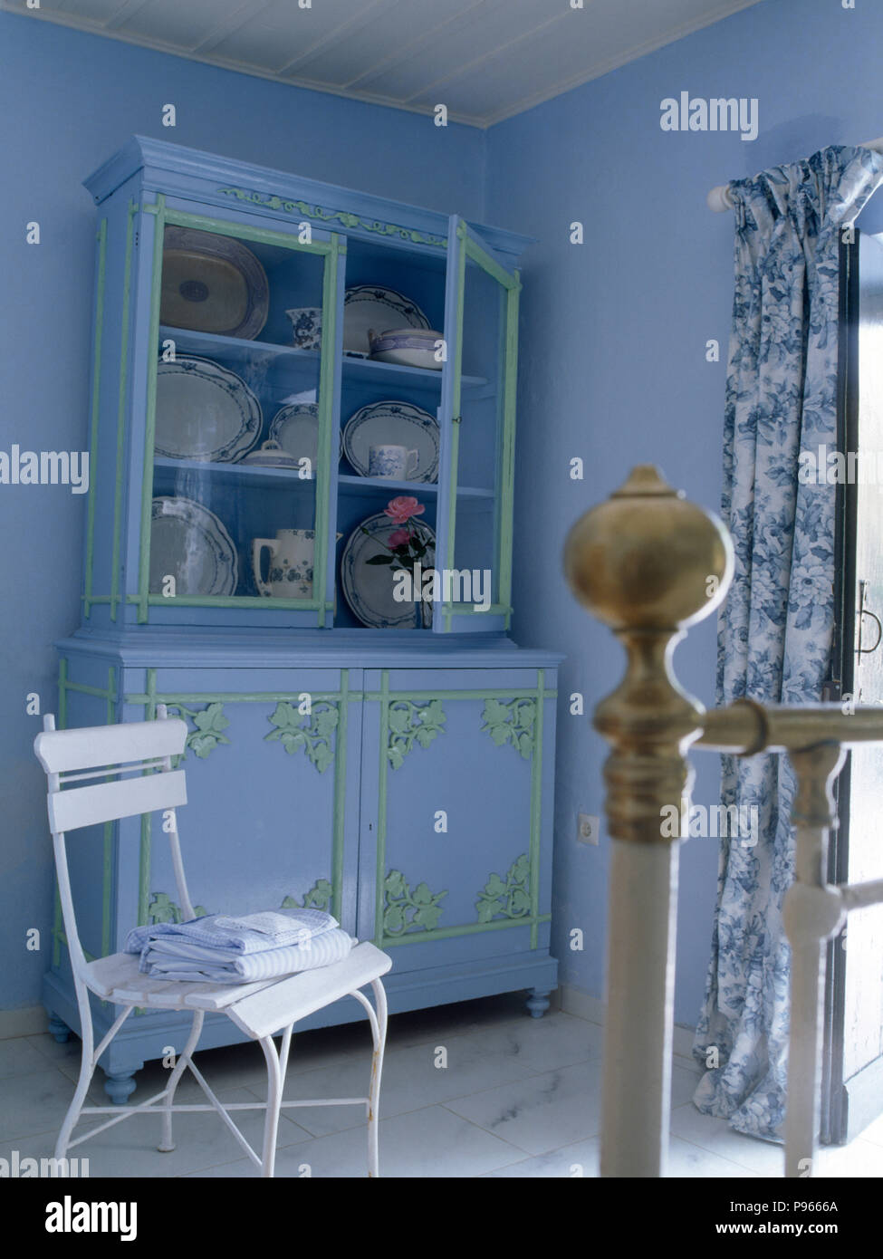 Chaise blanche et bleu pâle peint commode dans une chambre bleu pâle Banque D'Images