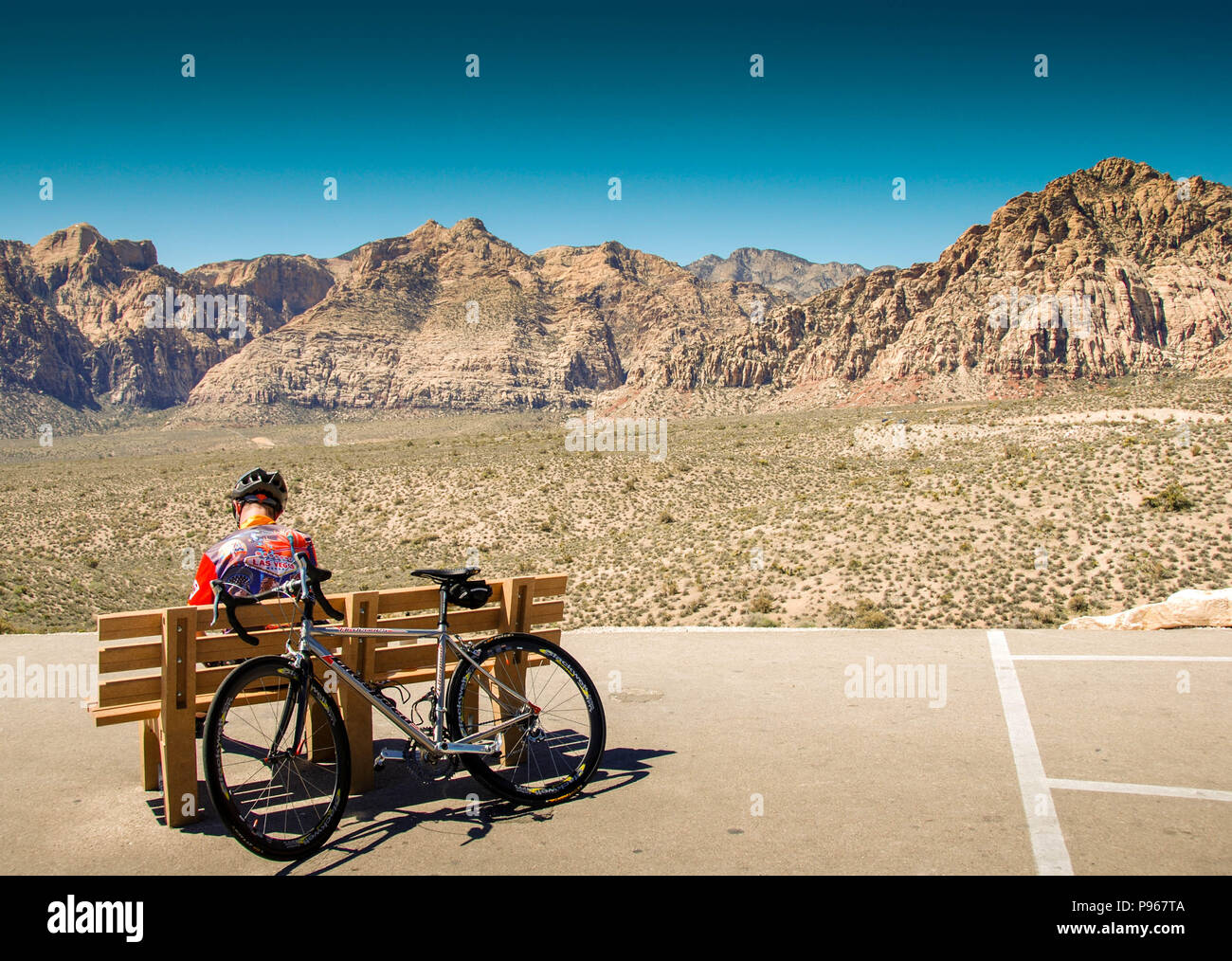 Cycliste en appui sur un banc dans le Red Rock Canyon National Conservation Area, dans la banlieue de Las Vegas, Nevada. Banque D'Images