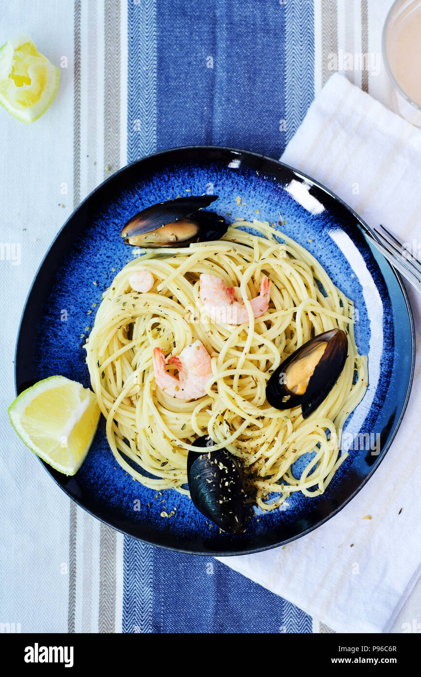 Les pâtes italiennes avec des fruits de mer sur fond bleu et blanc, nappe. Italian food concept, la nutrition Banque D'Images