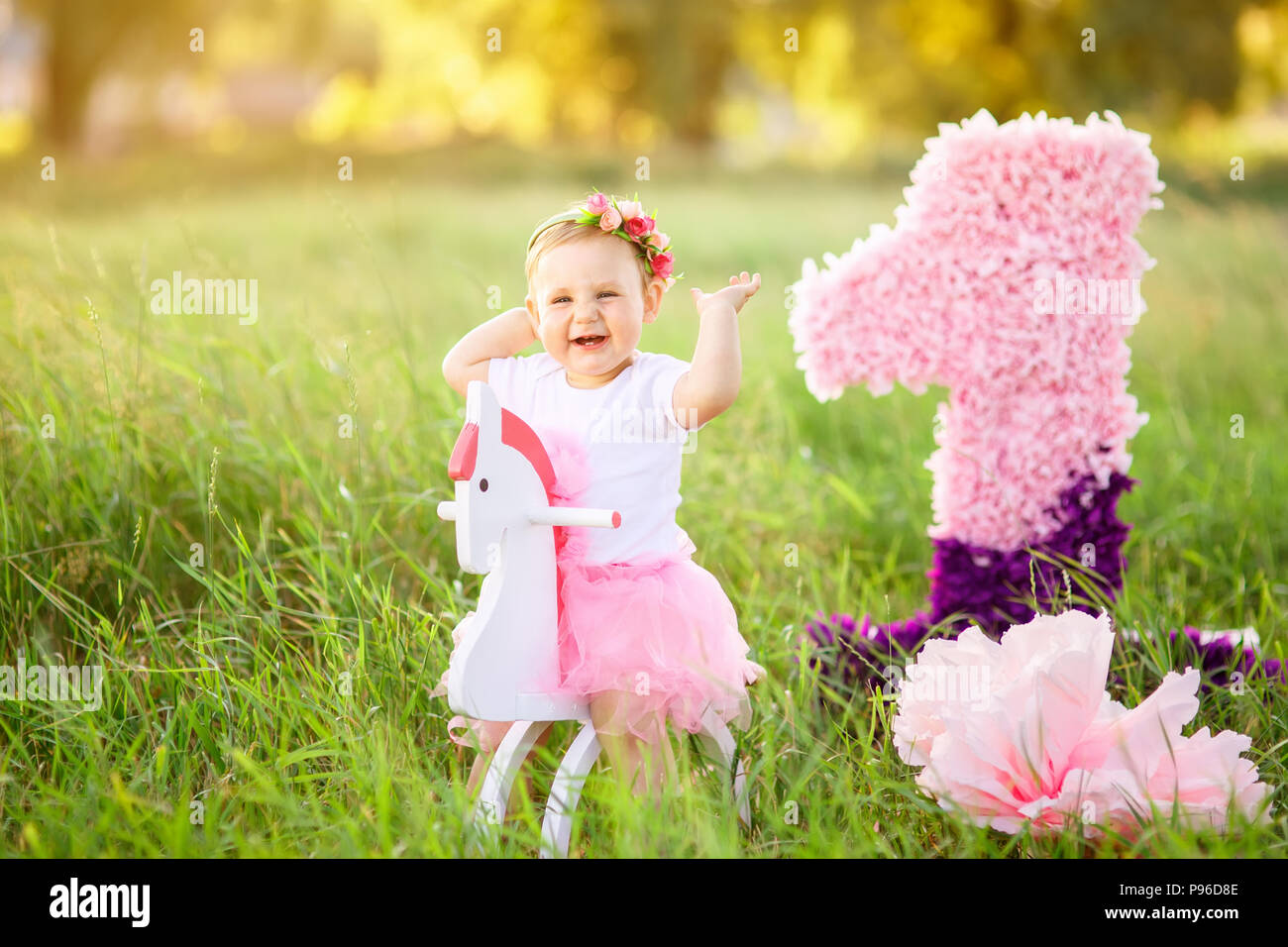 Belle Petite Fille En Robe Rose Equitation Sur Cheval Jouet En Bois A L Exterieur La Celebration De La Premiere Notion D Anniversaire Photo Stock Alamy