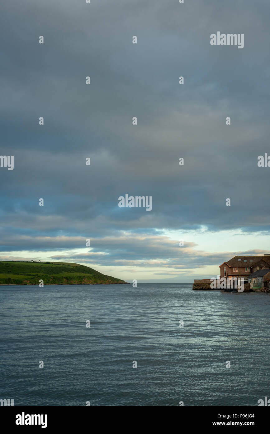 Avec vue sur la mer spectaculaire Youghal bay et la rivière Blackwater au crépuscule. Maison de bord de mer et colline en lumière douce. Ciel nuageux Ciel d'orage seascape harbour port Banque D'Images