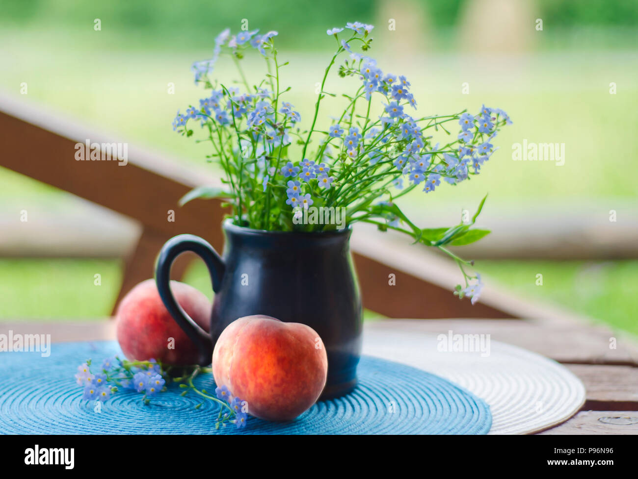 Nature morte avec fleurs des champs et les pêches. Fleurs dans vase avec peach fruits sur une table dans un chalet d'été Banque D'Images