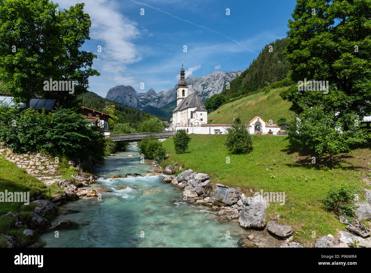 Jolie scène ensoleillée de l'église blanche, rivière et montagne à Ramsau Bei Berchtesgaden, en Bavière Banque D'Images