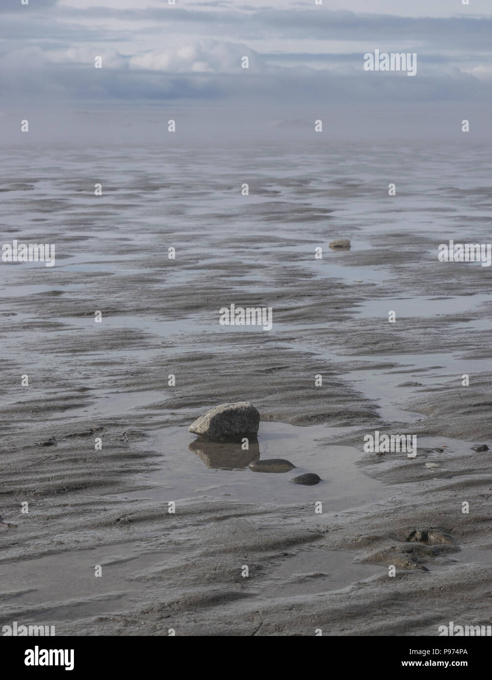 Rochers sur la côte de l'estran de l'Alaska sur un ciel bleu voilé de brouillard et de jour. Banque D'Images