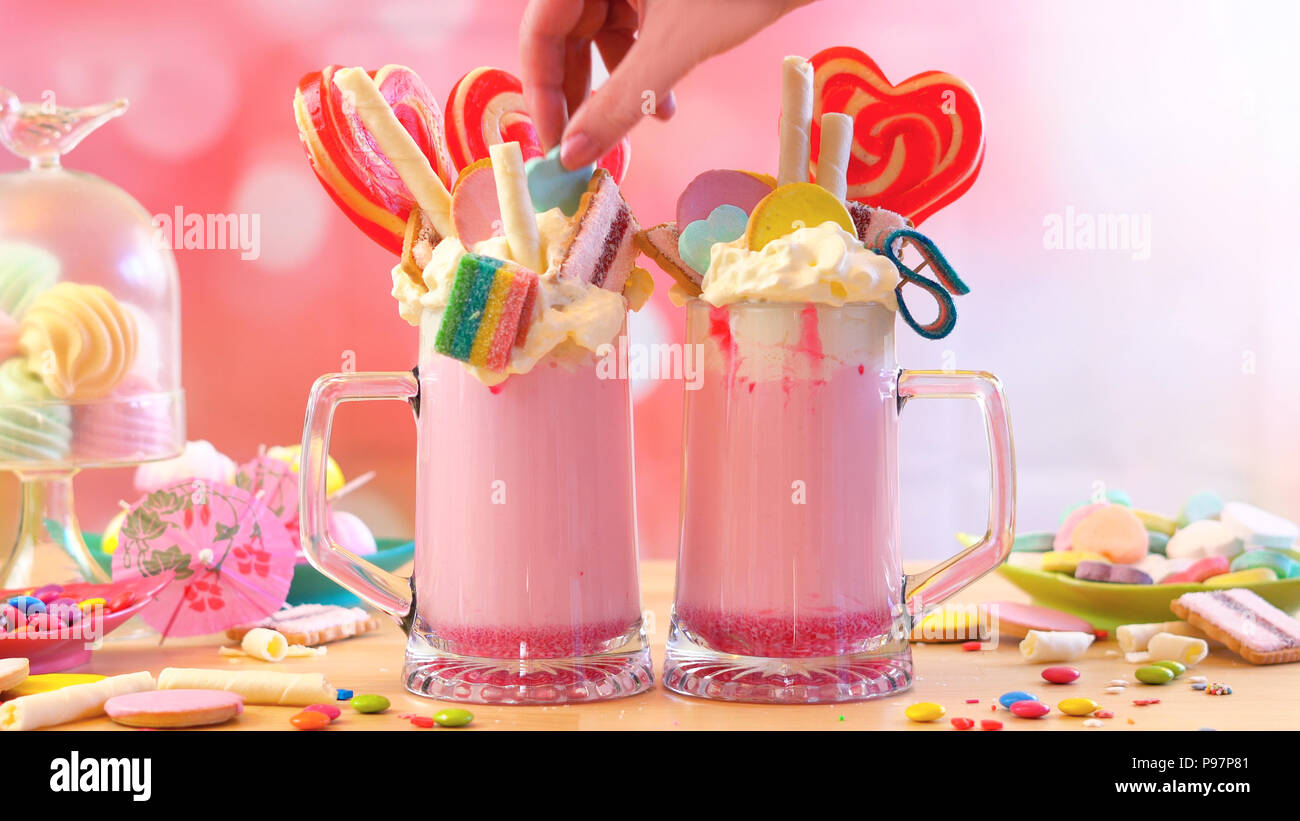 La tendance populaire moderne freak fraise milkshakes toppping secoue avec sucettes bonbons et biscuits, selective focus. Banque D'Images