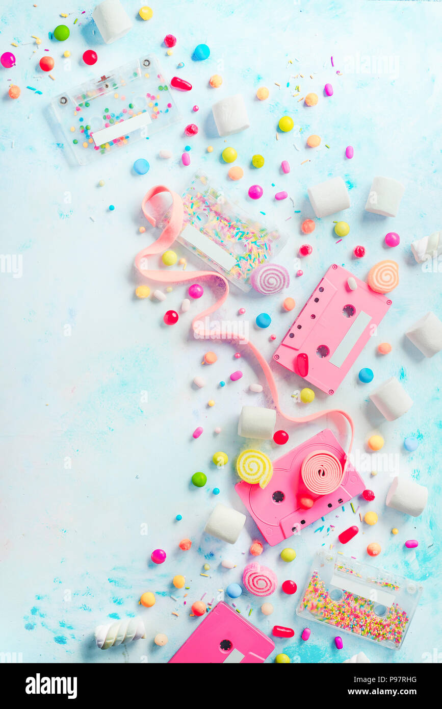 Cassettes rose dans une douce mélodie concept. Bonbons, arrose et marmelades sur fond clair avec l'exemplaire de l'espace. Télévision couleur pastel lay Banque D'Images