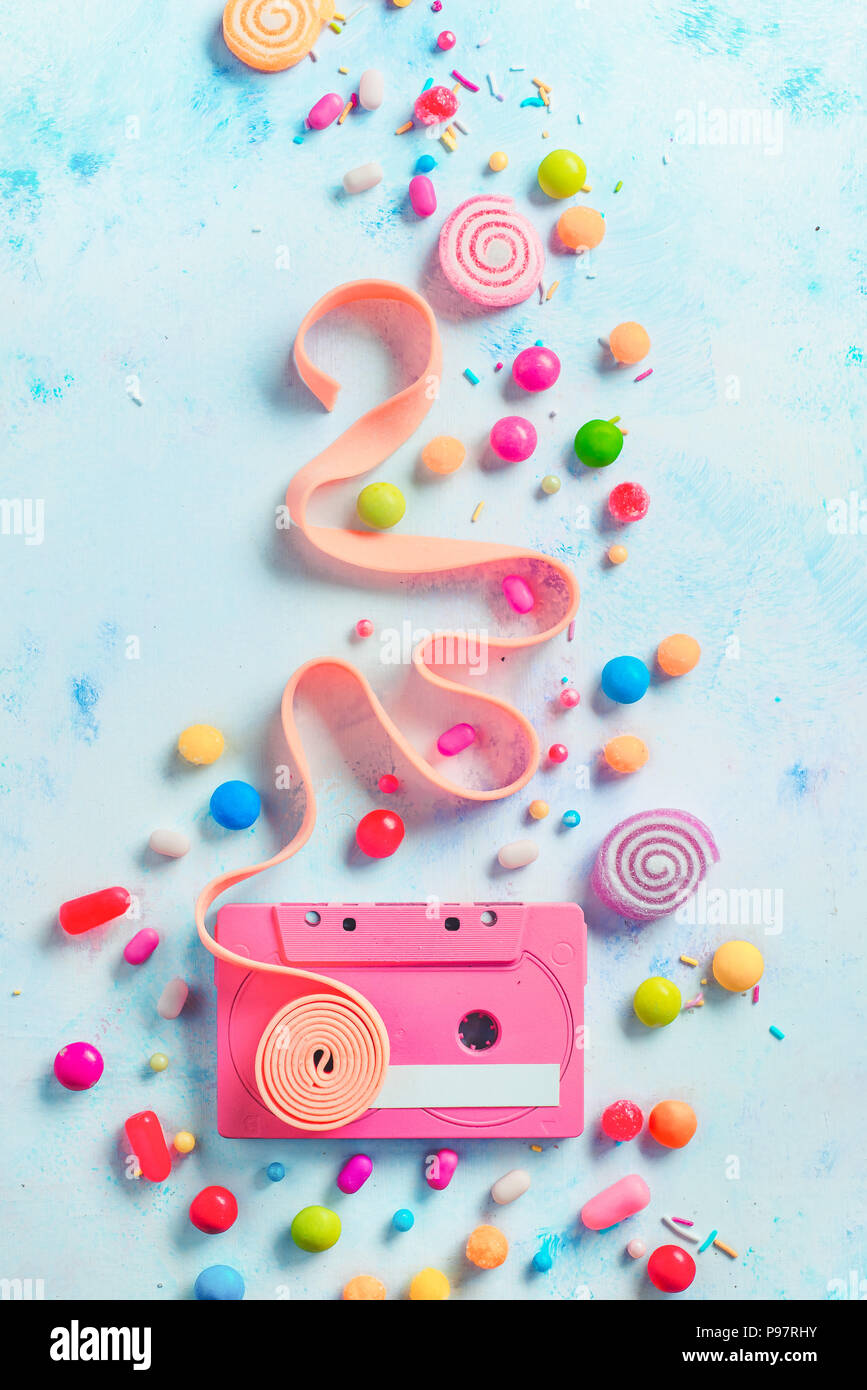 Cassette rose avec une bande de bubble gum dans une douce et douce musique concept avec copie espace. Bonbons, sprinkles, marmelades et dans une couleur pastel avec des bonbons mise à plat Banque D'Images