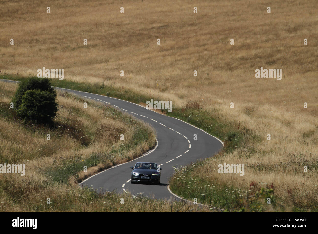 Beachy Head, UK - 14 juillet 2018 : Une route traverse le pays des prairies de l'Eastbourne Downland Estate par Beachy Head sur une chaude journée d'été le 14 juillet 2018. Porté à des températures de 27 degrés et devrait rester élevé pendant un autre mois. La falaise, la plus haute falaise de craie en Grande-Bretagne s'élève à 162 mètres au-dessus du niveau de la mer et, malheureusement, l'un des plus fameux spots de suicide dans le monde. Crédit : David Mbiyu Banque D'Images