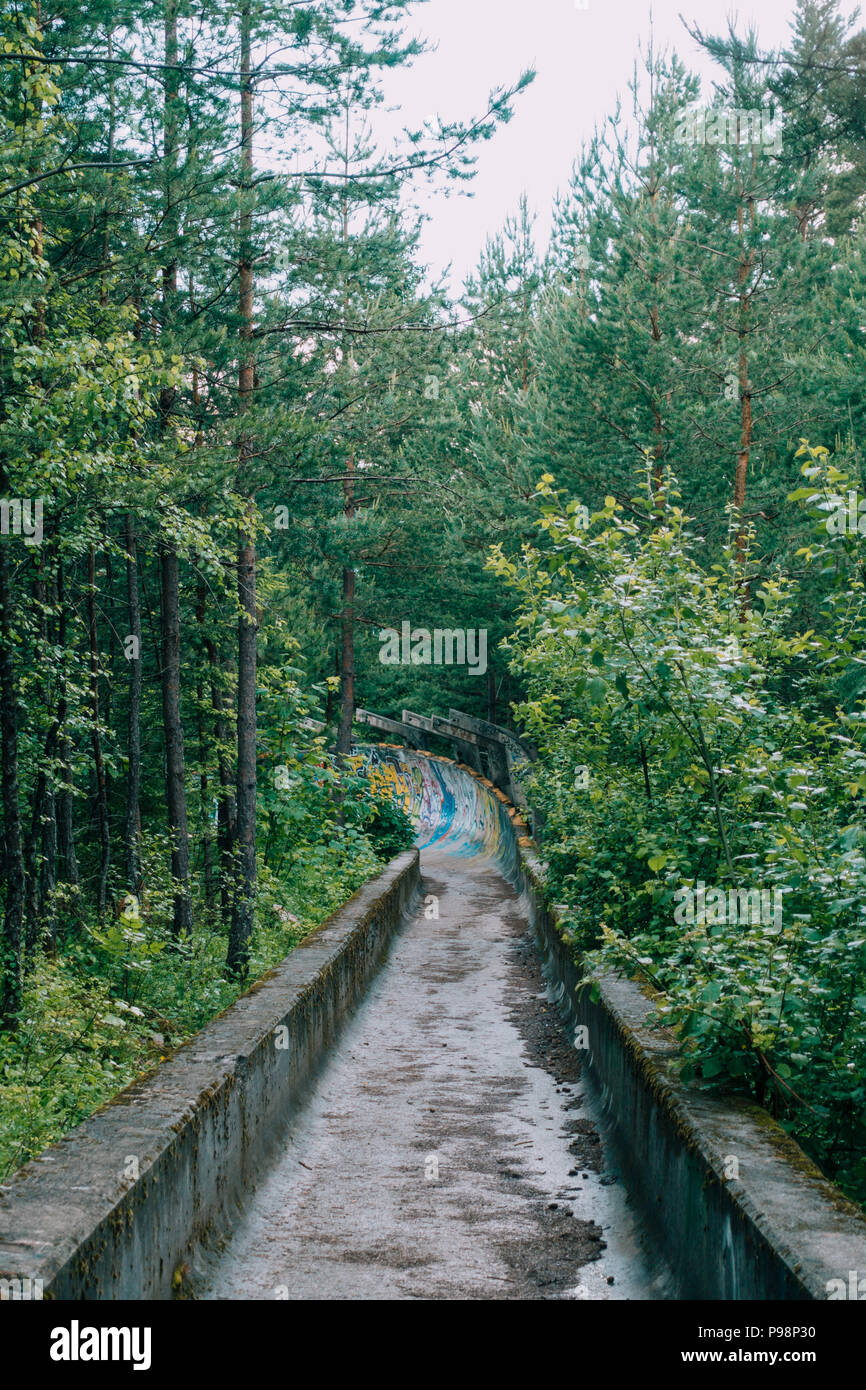 Le désormais ancien béton des Jeux Olympiques de Sarajevo 1984 piste de bobsleigh et de luge à travers la forêt des courbes, couverts de graffitis Banque D'Images