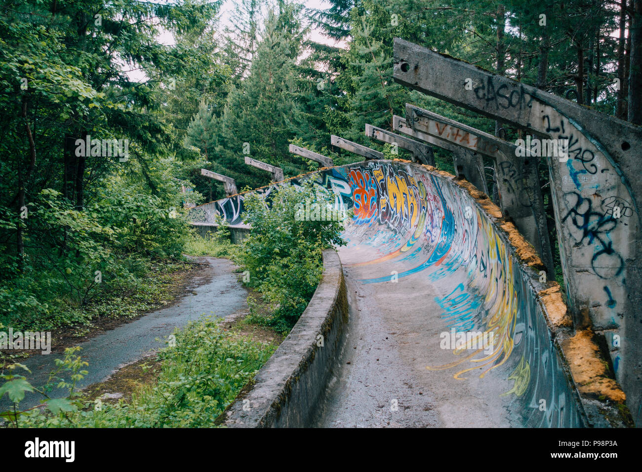 Le désormais ancien béton des Jeux Olympiques de Sarajevo 1984 piste de bobsleigh et de luge à travers la forêt des courbes, couverts de graffitis Banque D'Images
