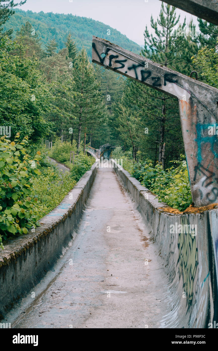 Le désormais ancien béton des Jeux Olympiques de Sarajevo 1984 piste de bobsleigh et de luge à travers la forêt des courbes, couverts de graffitis Banque D'Images