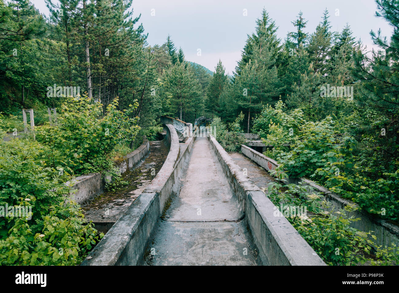 Le désormais ancien béton des Jeux Olympiques de Sarajevo 1984 piste de bobsleigh et de luge à travers la forêt des courbes, couverts de graffitis Banque D'Images