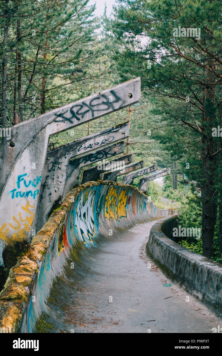 Le désormais ancien béton des Jeux Olympiques de Sarajevo 1984 piste de bobsleigh et de luge à travers la forêt des courbes, couverts de graffitis Banque D'Images