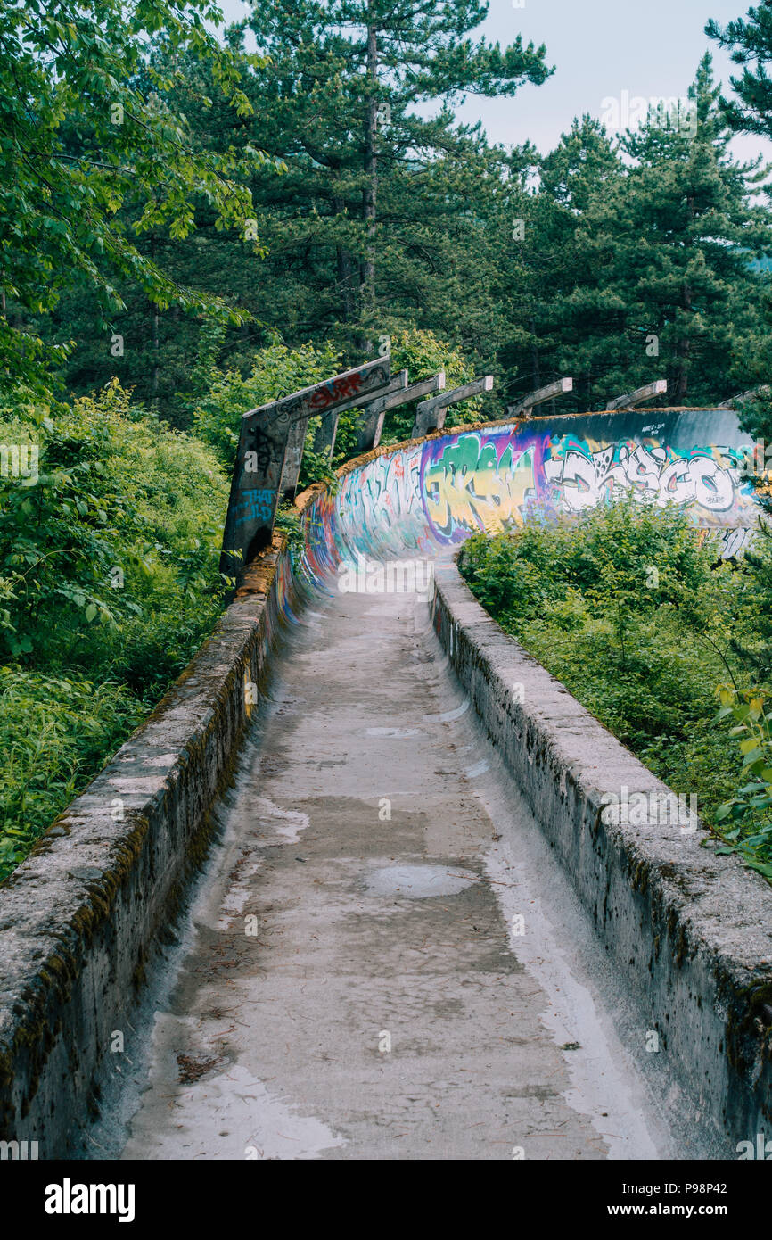 Le désormais ancien béton des Jeux Olympiques de Sarajevo 1984 piste de bobsleigh et de luge à travers la forêt des courbes, couverts de graffitis Banque D'Images