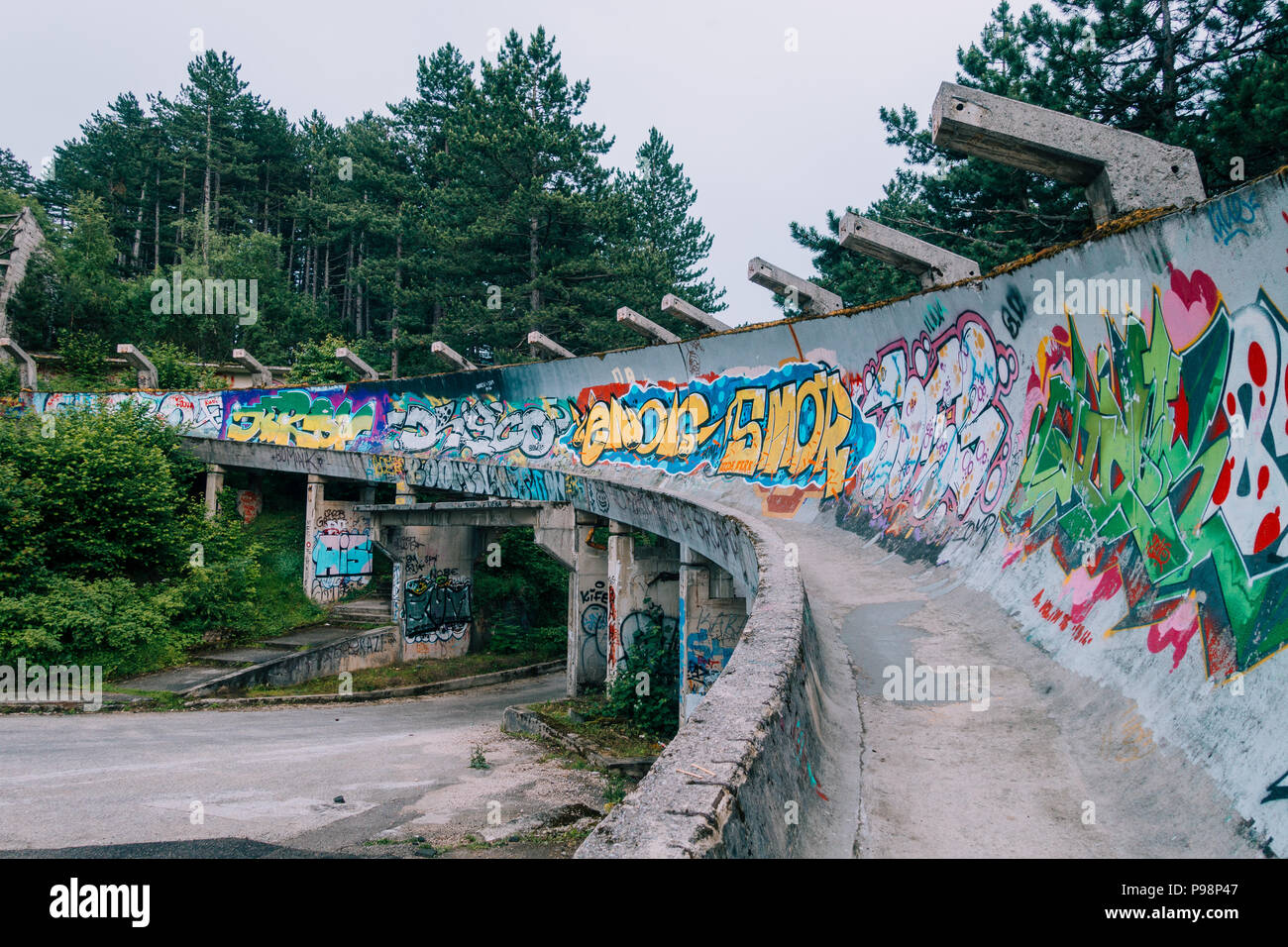 Le désormais ancien béton des Jeux Olympiques de Sarajevo 1984 piste de bobsleigh et de luge à travers la forêt des courbes, couverts de graffitis Banque D'Images