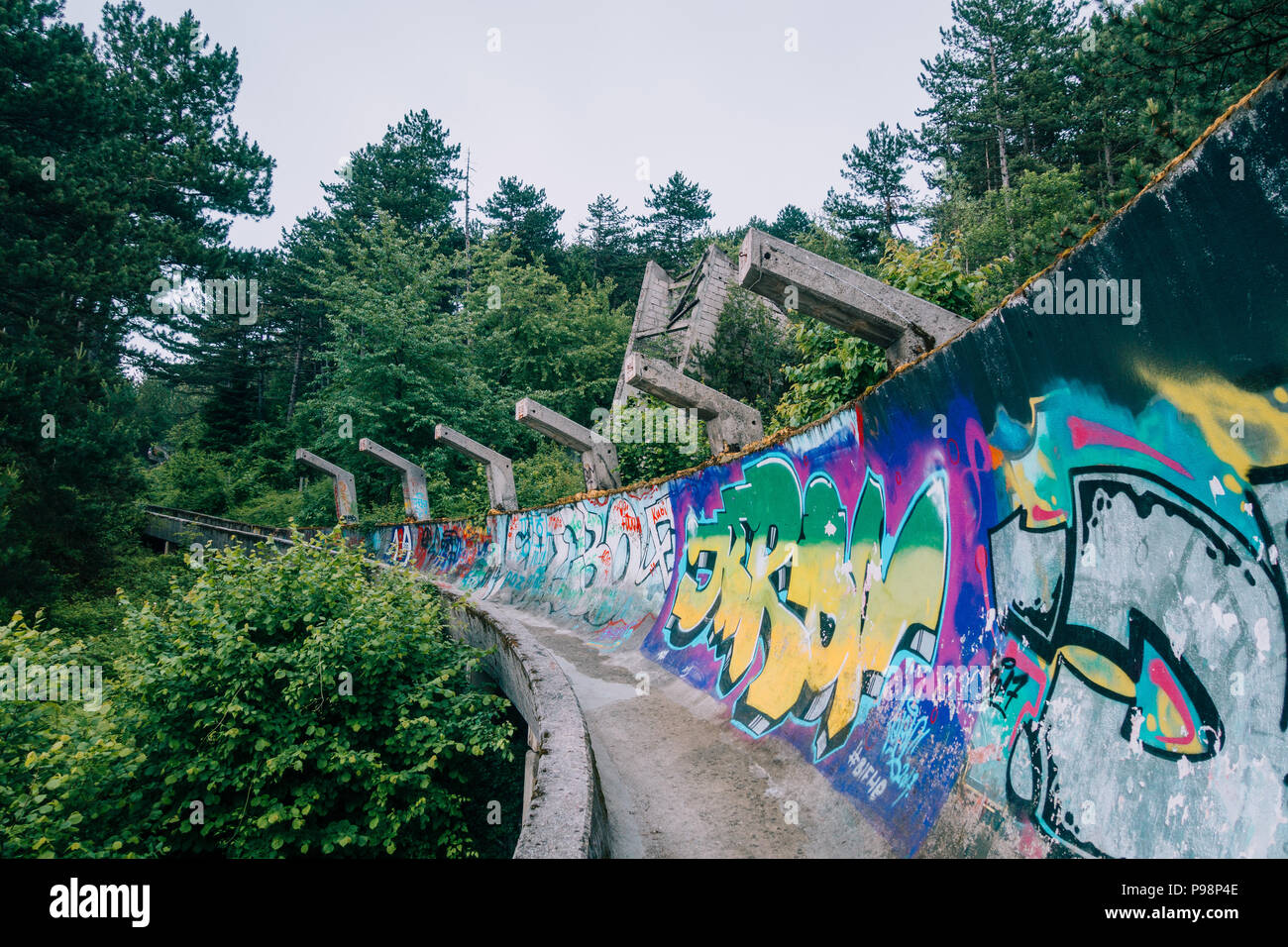 Le désormais ancien béton des Jeux Olympiques de Sarajevo 1984 piste de bobsleigh et de luge à travers la forêt des courbes, couverts de graffitis Banque D'Images