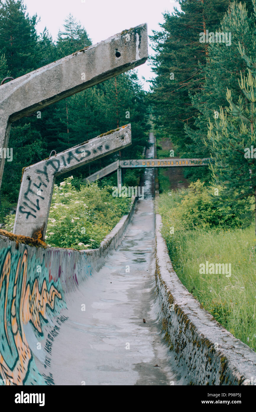 Le désormais ancien béton des Jeux Olympiques de Sarajevo 1984 piste de bobsleigh et de luge à travers la forêt des courbes, couverts de graffitis Banque D'Images