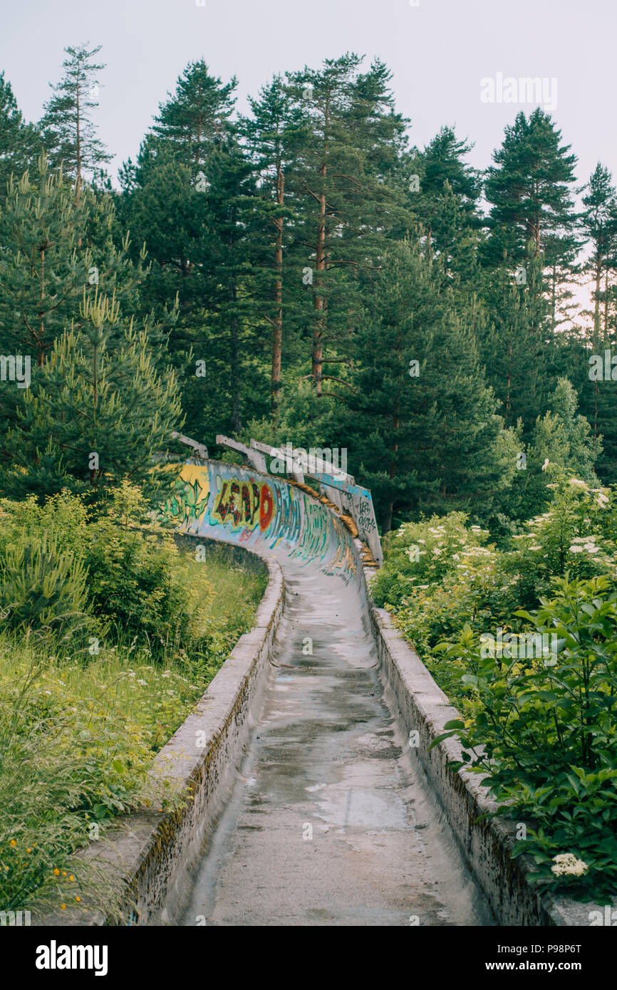 Le désormais ancien béton des Jeux Olympiques de Sarajevo 1984 piste de bobsleigh et de luge à travers la forêt des courbes, couverts de graffitis Banque D'Images
