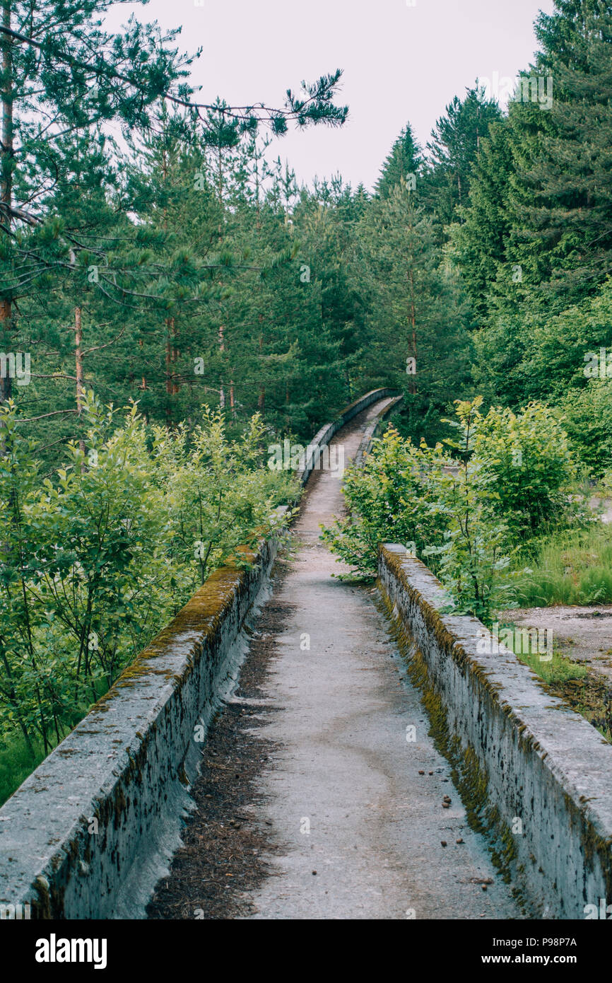 Le désormais ancien béton des Jeux Olympiques de Sarajevo 1984 piste de bobsleigh et de luge à travers la forêt des courbes, couverts de graffitis Banque D'Images