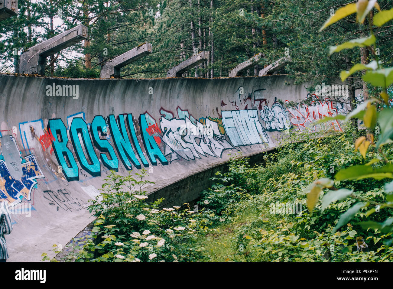 Le désormais ancien béton des Jeux Olympiques de Sarajevo 1984 piste de bobsleigh et de luge à travers la forêt des courbes, couverts de graffitis Banque D'Images