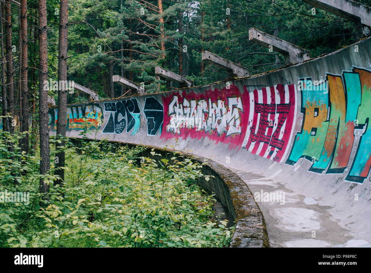 Le désormais ancien béton des Jeux Olympiques de Sarajevo 1984 piste de bobsleigh et de luge à travers la forêt des courbes, couverts de graffitis Banque D'Images