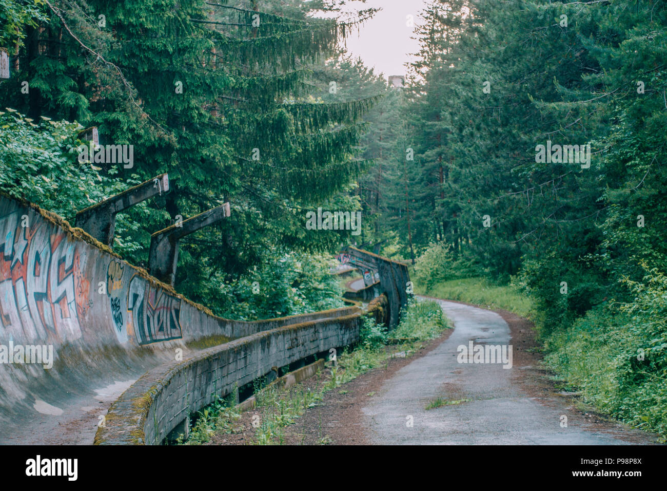 Le désormais ancien béton des Jeux Olympiques de Sarajevo 1984 piste de bobsleigh et de luge à travers la forêt des courbes, couverts de graffitis Banque D'Images