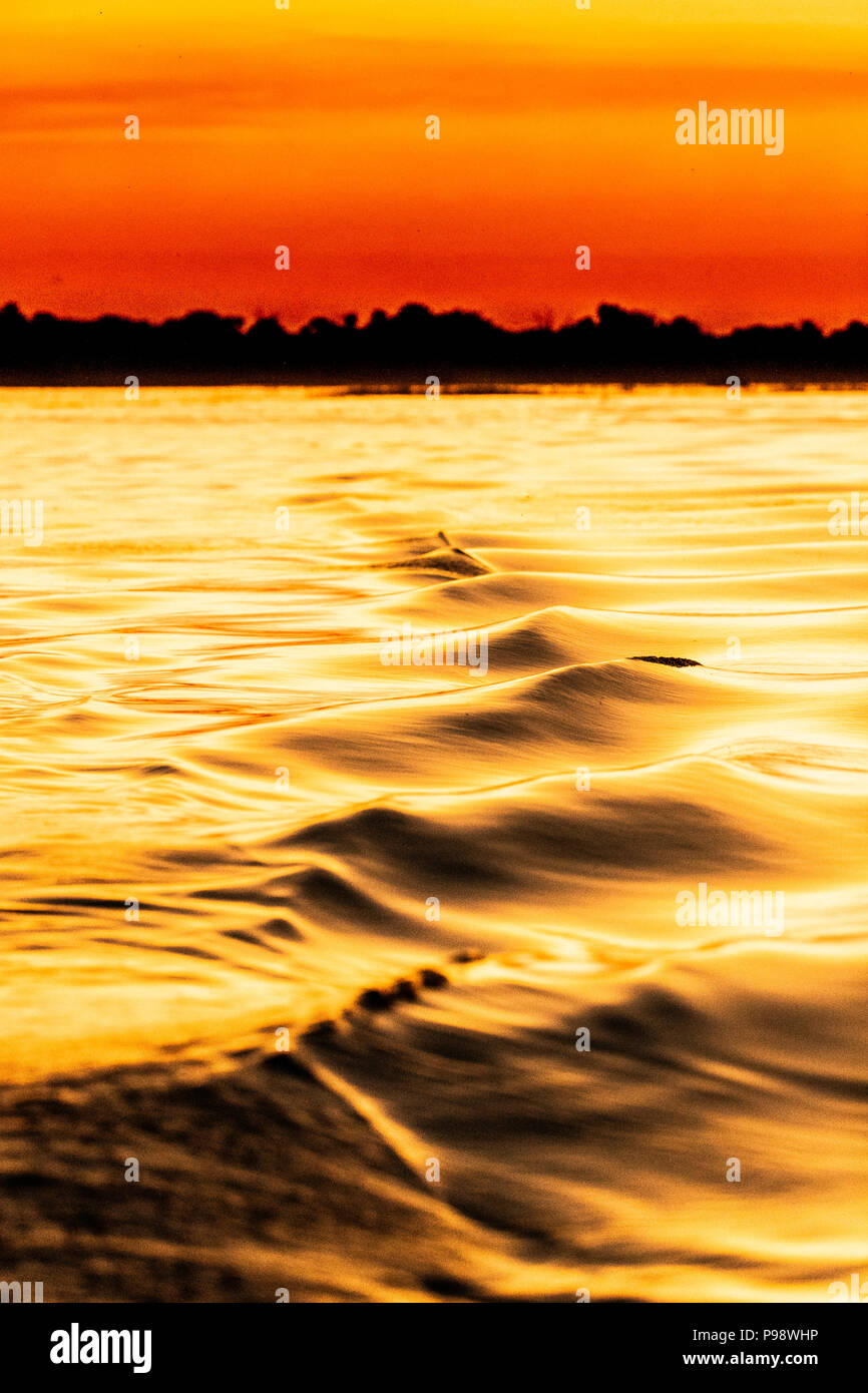 Ondulations dans le service du bateau, rivière Chobe au coucher du soleil. Botswana Banque D'Images
