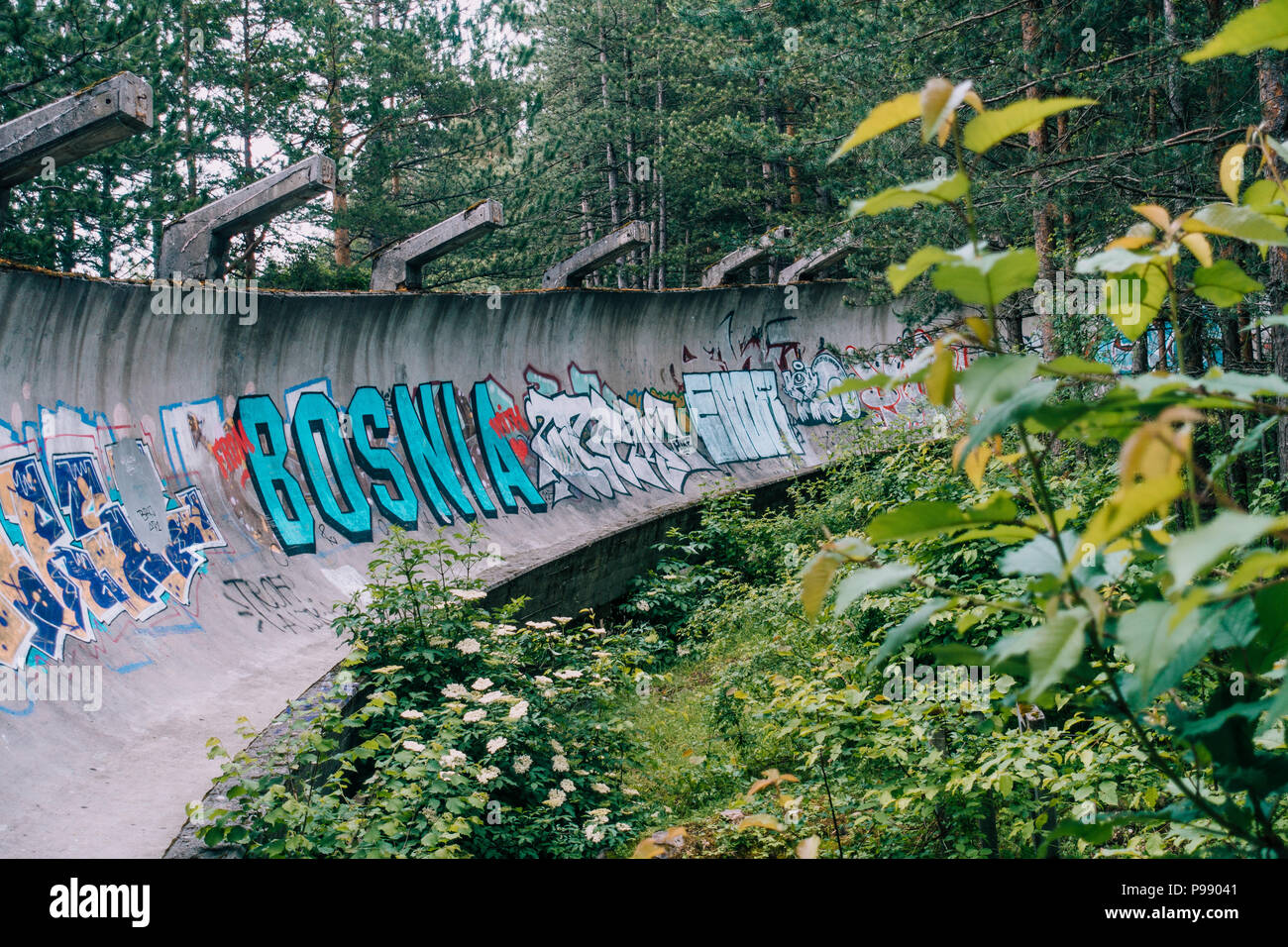Le désormais ancien béton des Jeux Olympiques de Sarajevo 1984 piste de bobsleigh et de luge à travers la forêt des courbes, couverts de graffitis Banque D'Images