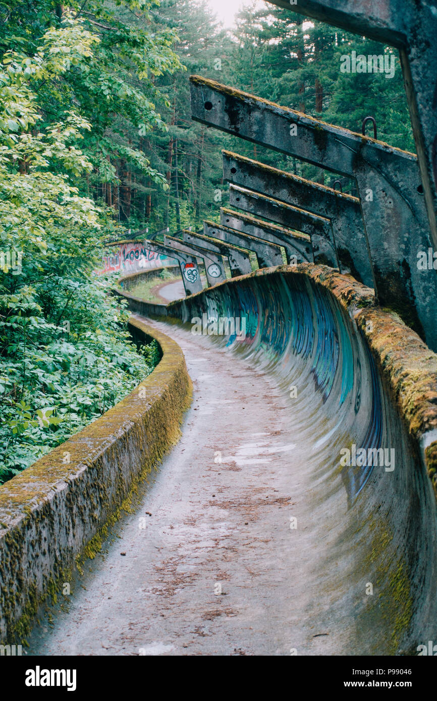 Le désormais ancien béton des Jeux Olympiques de Sarajevo 1984 piste de bobsleigh et de luge à travers la forêt des courbes, couverts de graffitis Banque D'Images