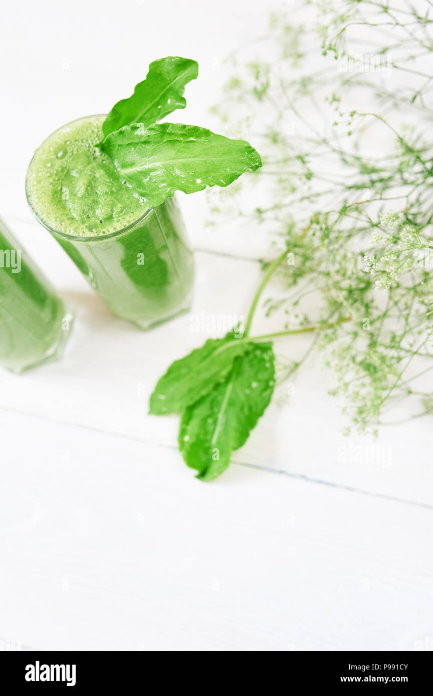 Smoothie vert mélangé avec des ingrédients ou un cocktail sur fond blanc, petit déjeuner végétalien avec une place pour votre texte, concept de matières premières alimentaires Banque D'Images
