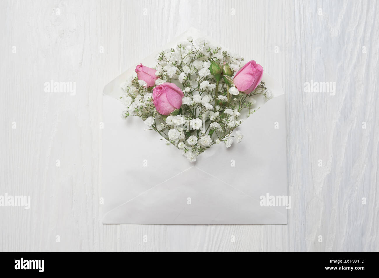 Enveloppe maquette avec des fleurs et une lettre, carte de souhaits pour la Saint-Valentin de mariage avec place pour votre texte. Mise à plat, haut voir photo maquette Banque D'Images