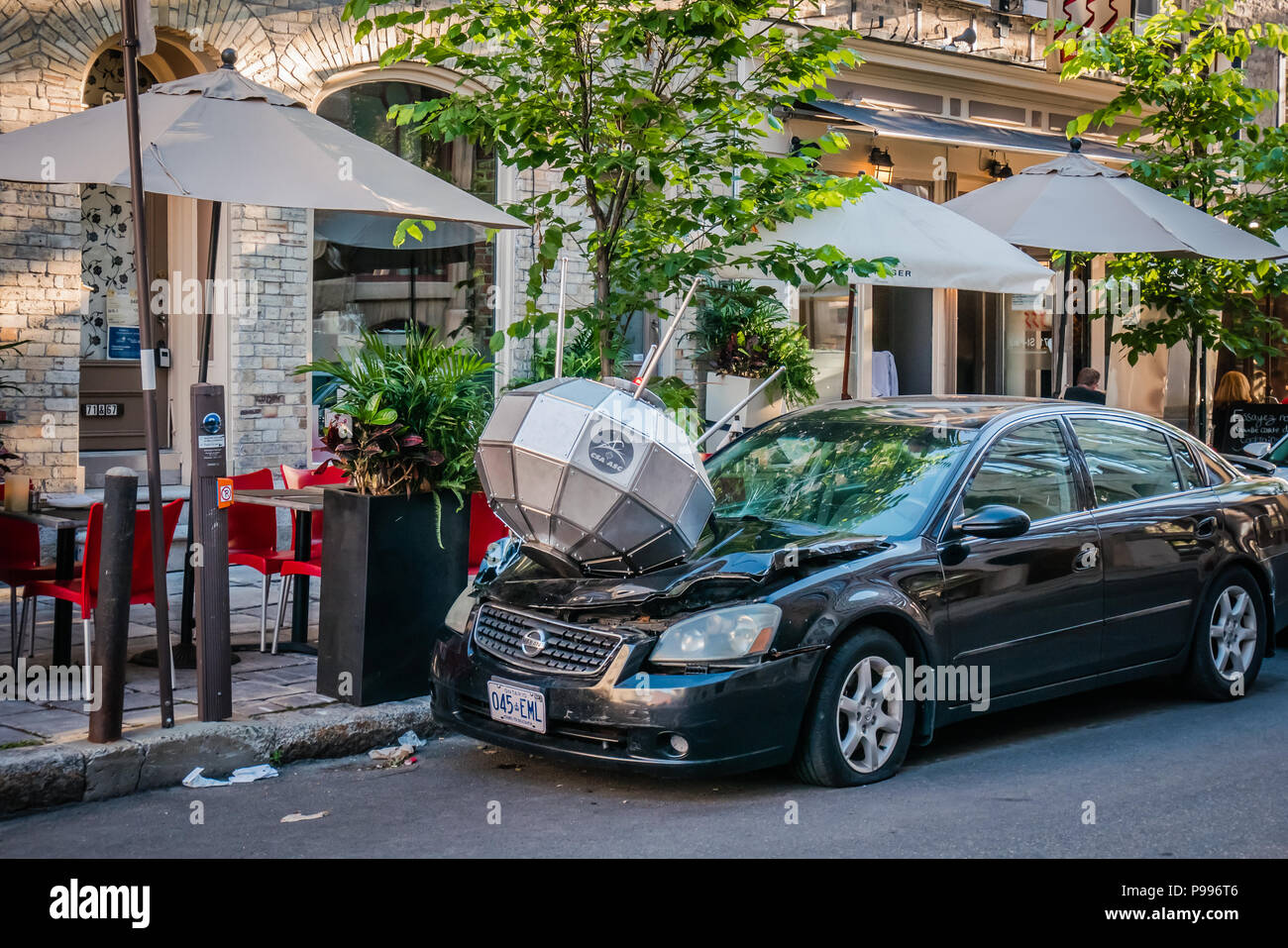 Un objet argenté endommagé l'avant d'une voiture noire Banque D'Images